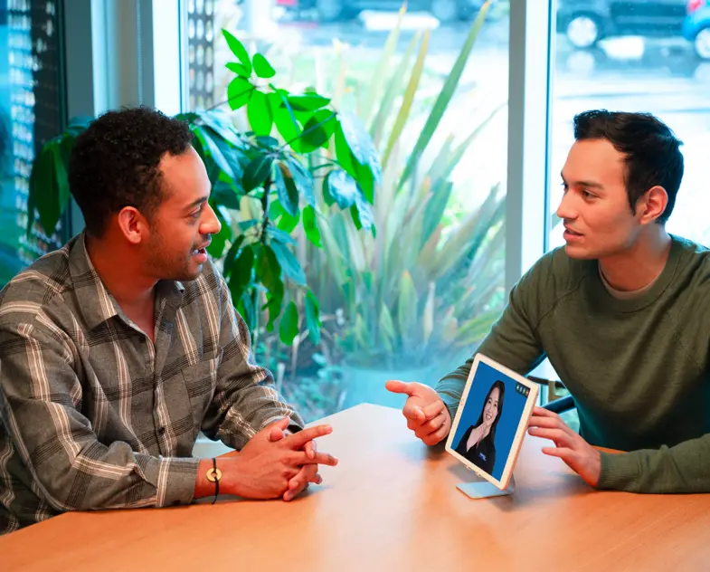 A financial services customer talks to an adviser with a video interpreter's help.